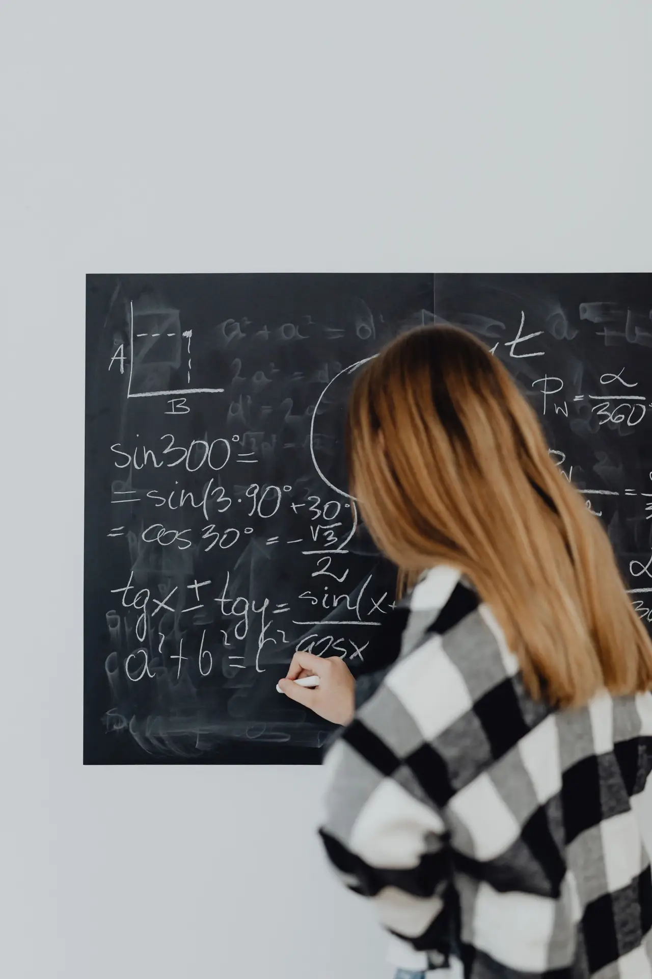 Mathematics student working on a blackboard