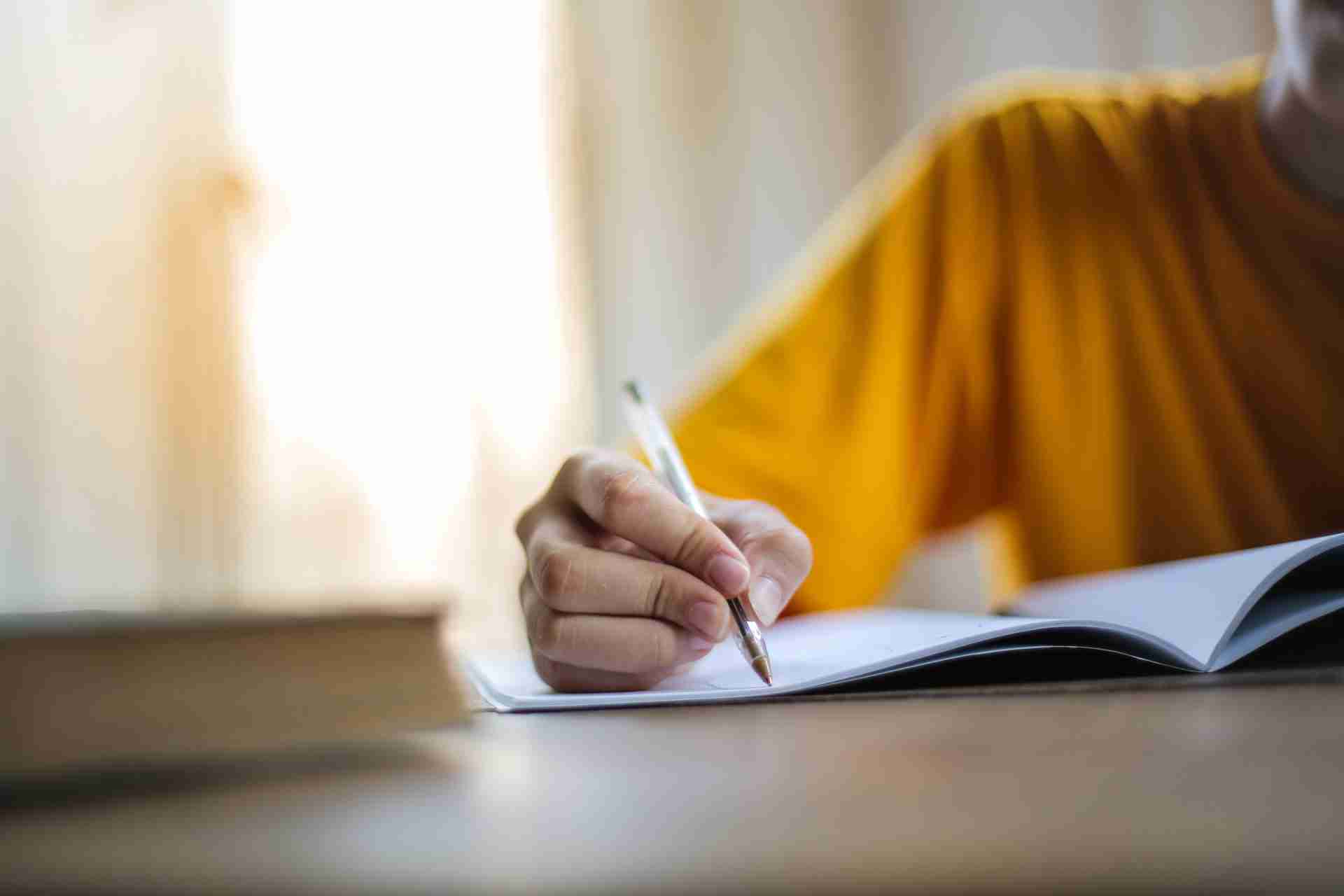 Someone writing into a book