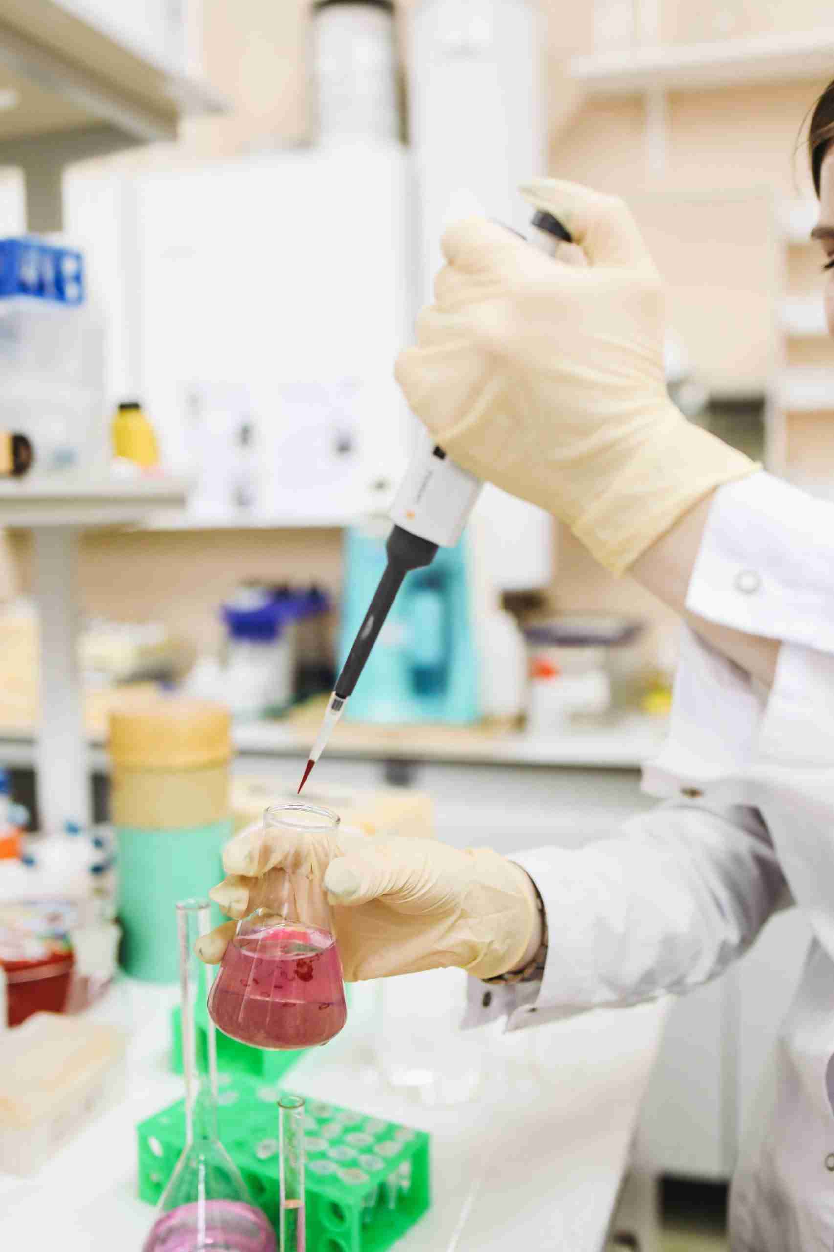 Scientist pipetting liquid into a conical flask
