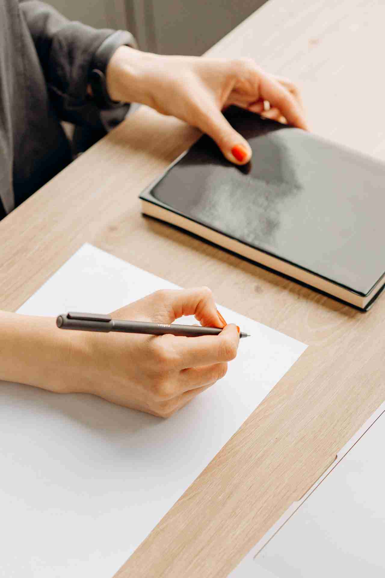 Person writing on a blank sheet of paper